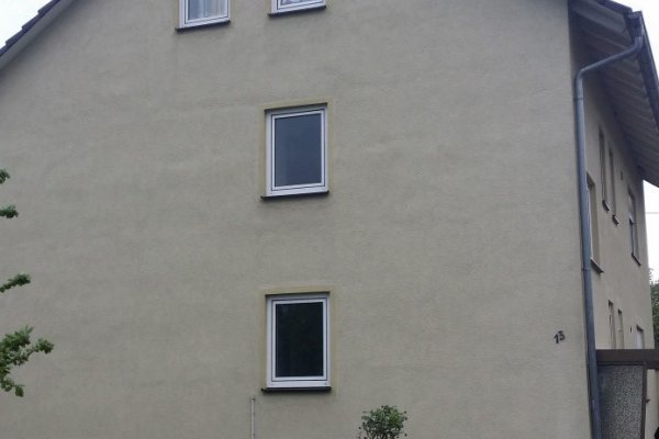 Von nahmen fotographierte hellelfenbeinfarbene Trauf-Fassade mit vier Fenstern